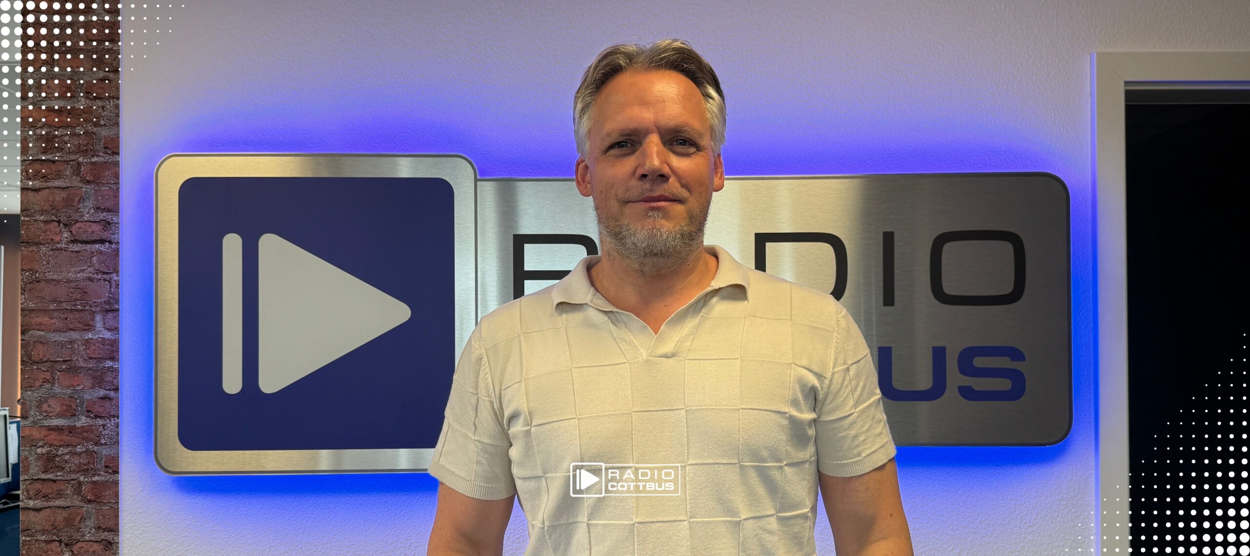 Marcel Linge vor den Radio Cottbus Logo