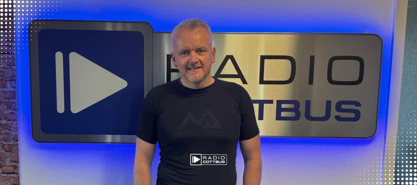 Mirko Prüfer vor dem Radio Cottbus Logo